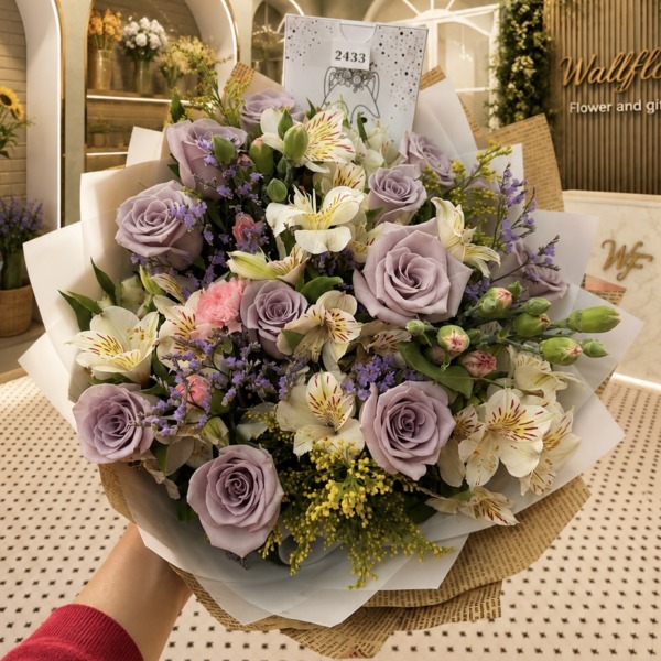 Ramo de rosas lavanda, astromelias blancas y statice morado en papel blanco y kraft — Wallflower Guatemala