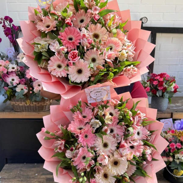 Dos ramos de gerberas rosadas, astromelias y mini claveles en papel rosado — Wallflower Guatemala
