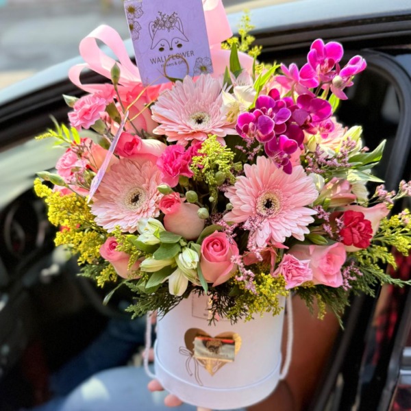 Caja sombrerera blanca con gerberas rosadas, orquídeas fucsia y rosas — Wallflower Guatemala